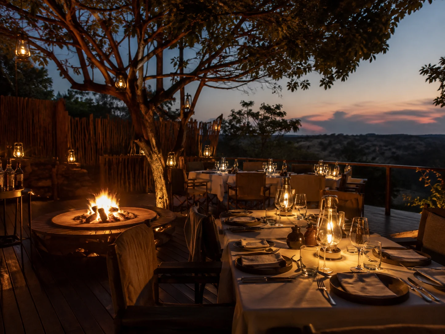 Open-air dining deck under lanterns at dusk